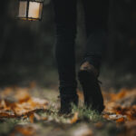 Man walking with a lantern in a woods